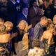 Crowd erupts with “get a room!” chants as Taylor Swift and Travis Kelce pack on the PDA, share a passionate kiss at the Songwriters Hall of Fame induction while Andrea Swift looks on proudly cheering them at star-studded gala